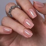 Nude Luxe Glow short squoval press-on nails worn on a hand
