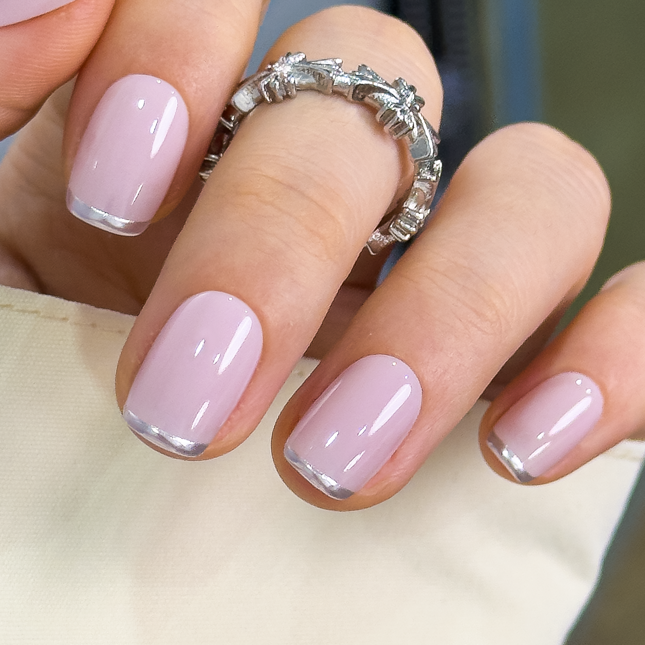 Nude Pink short squoval press-on nails worn on a hand