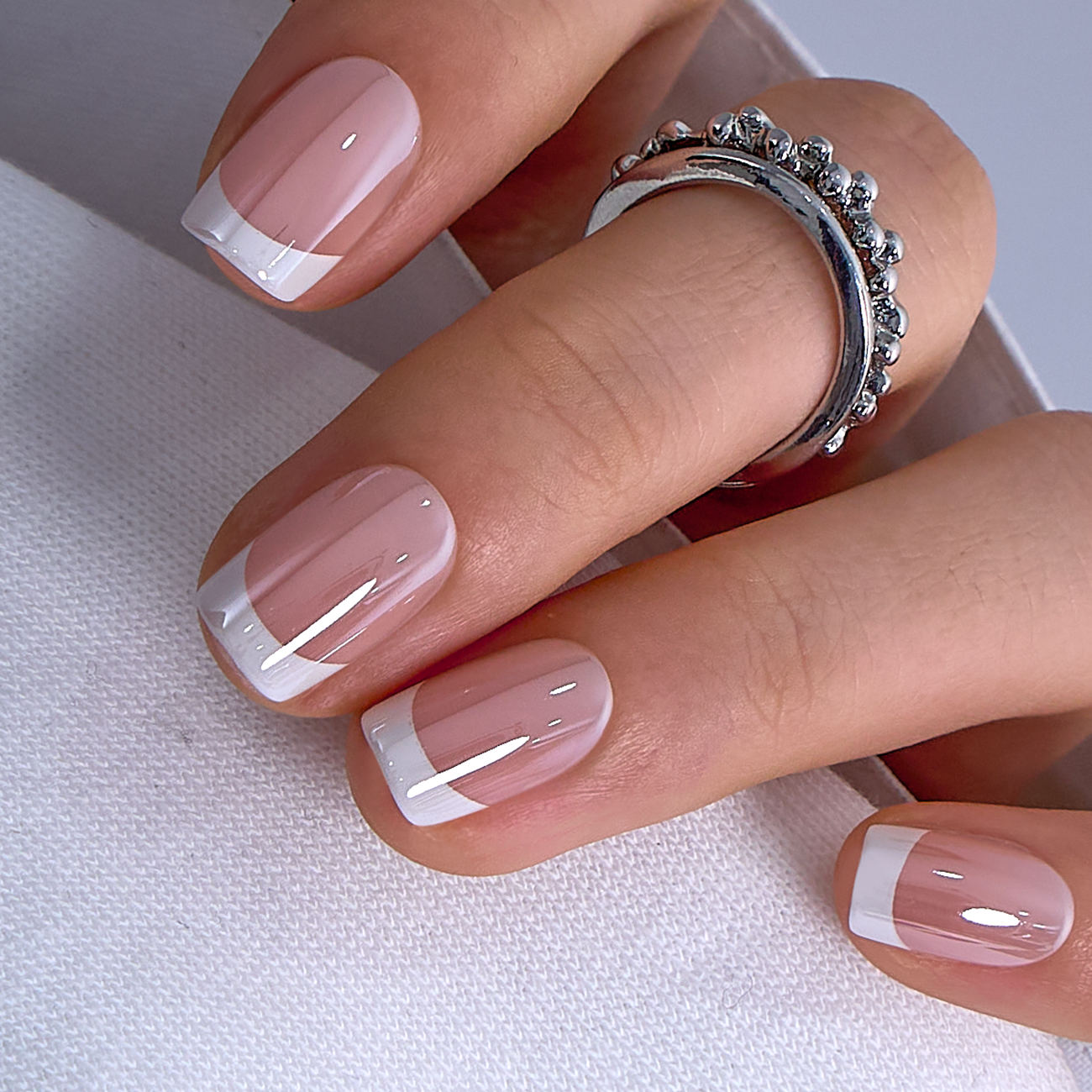 Nude Rhapsody medium squoval press-on nails worn on a hand