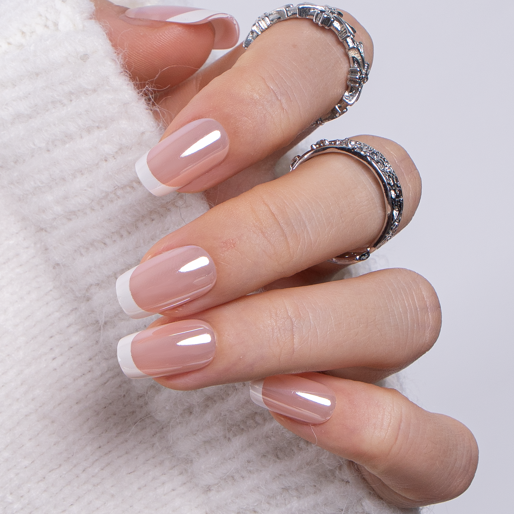 Nude Rhapsody short squoval press-on nails worn on a hand