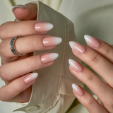 Nude Tips short almond press-on nails worn on a hand