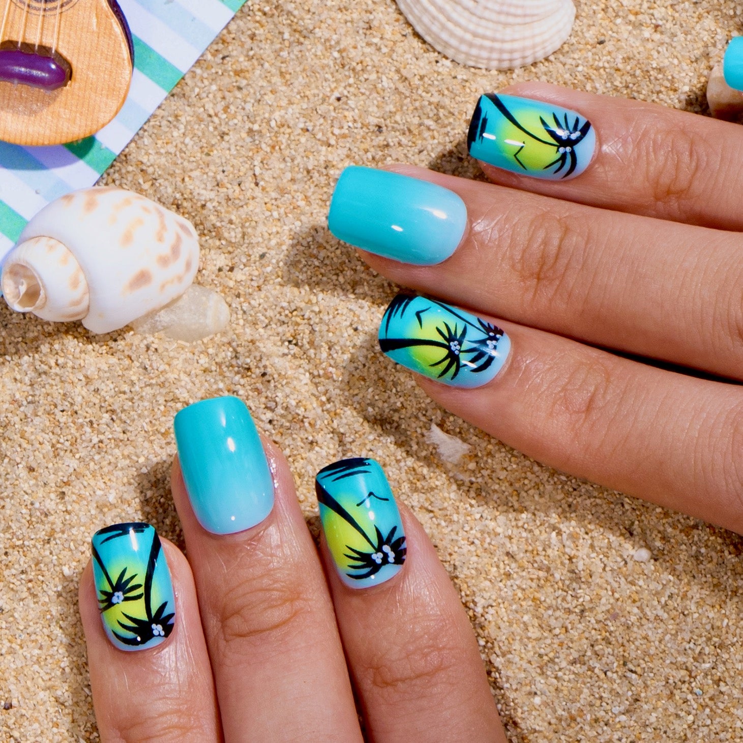 Ocean Palm short squoval press-on nails worn on a hand
