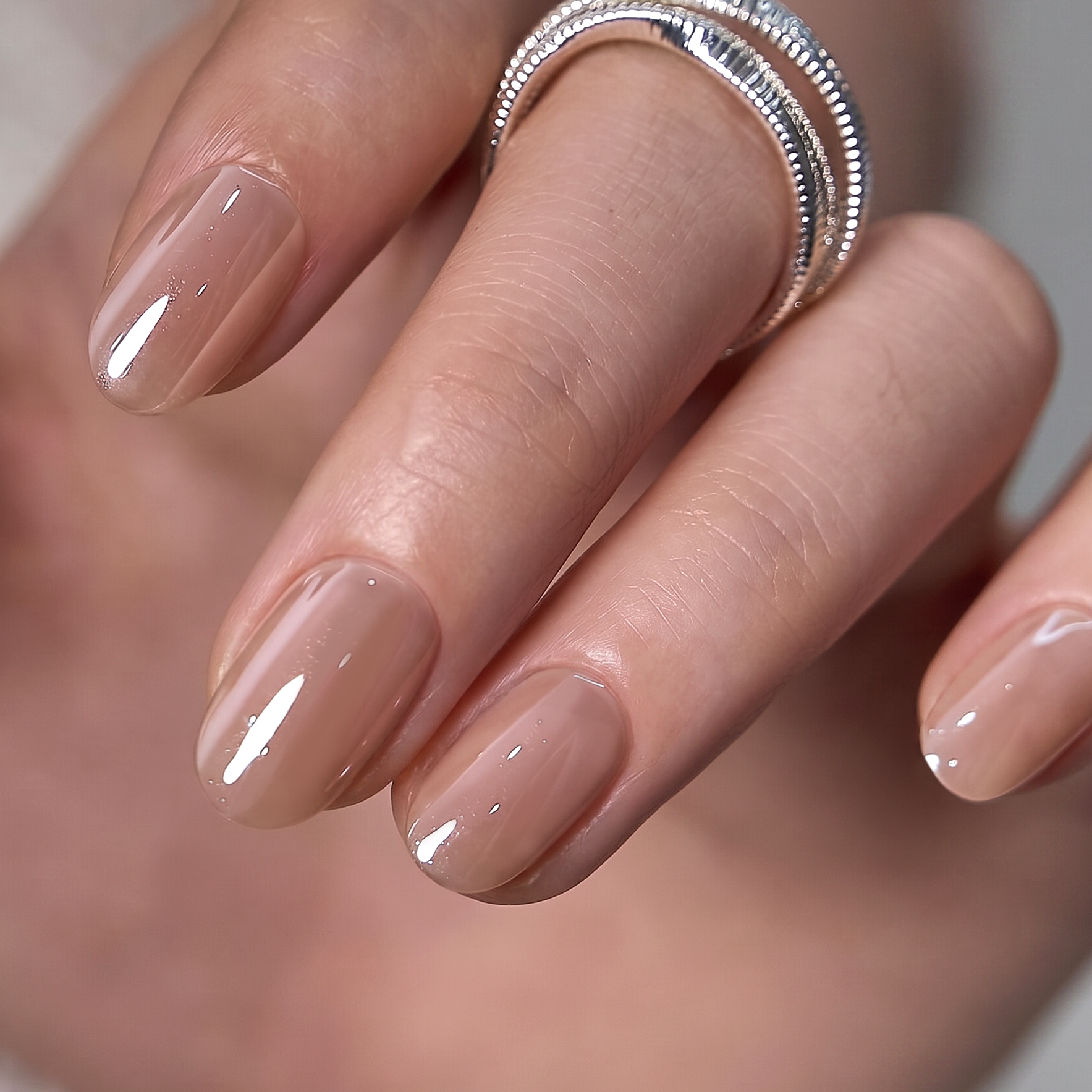 Pearl Pink Chic short oval press-on nails worn on a hand
