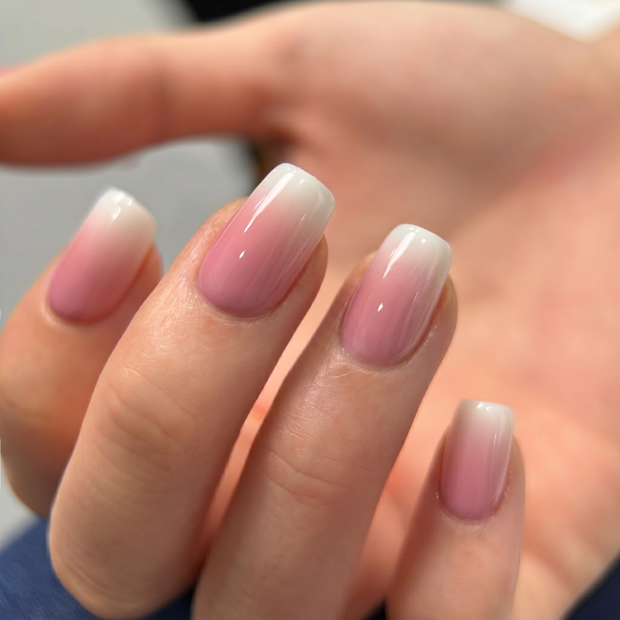 Pink Drift medium squoval press-on nails worn on a hand