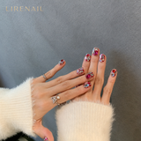 Lirenail press-on nails worn on hand covered in pink, red and clear crystal gem accents