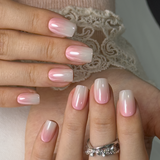 Pink Mist Charm short squoval press-on nails worn on a hand