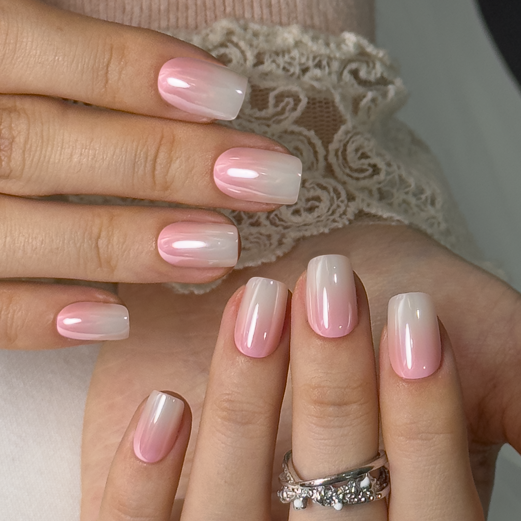 Pink Mist Charm short squoval press-on nails worn on a hand