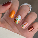 Pumpkin Harvest short squoval press-on nails worn on a hand