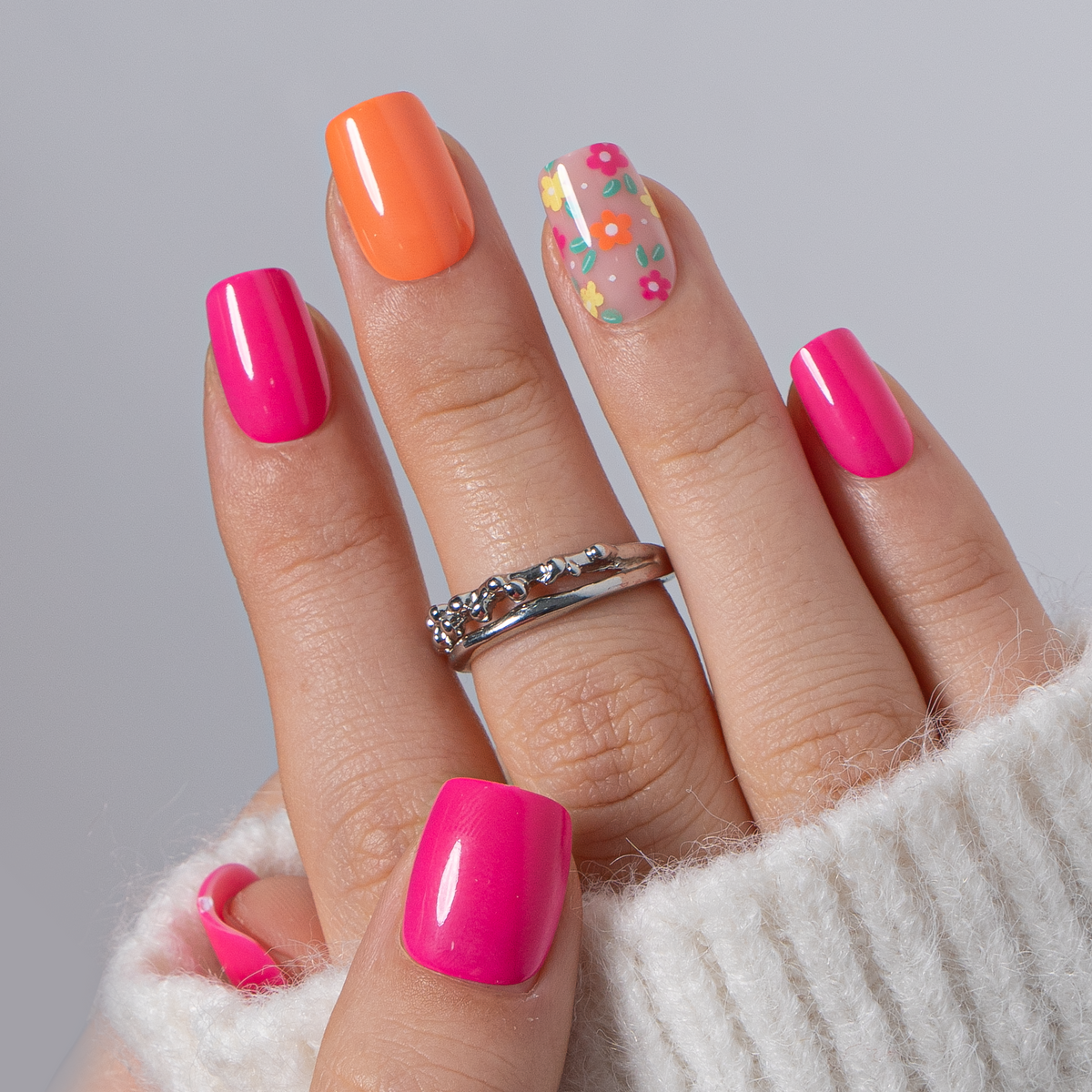 Rainbow Petal short squoval press-on nails worn on a hand
