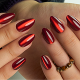 Red Eclipse short almond press-on nails worn on a hand
