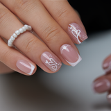 Romantic French short squoval press-on nails worn on a hand