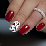Romantic Red short squoval press-on nails worn on a hand