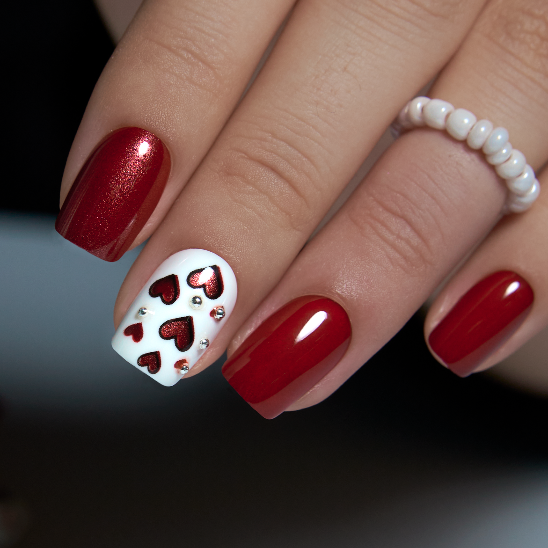 Romantic Red short squoval press-on nails worn on a hand