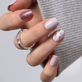 Rose Glint short squoval press-on nails worn on a hand