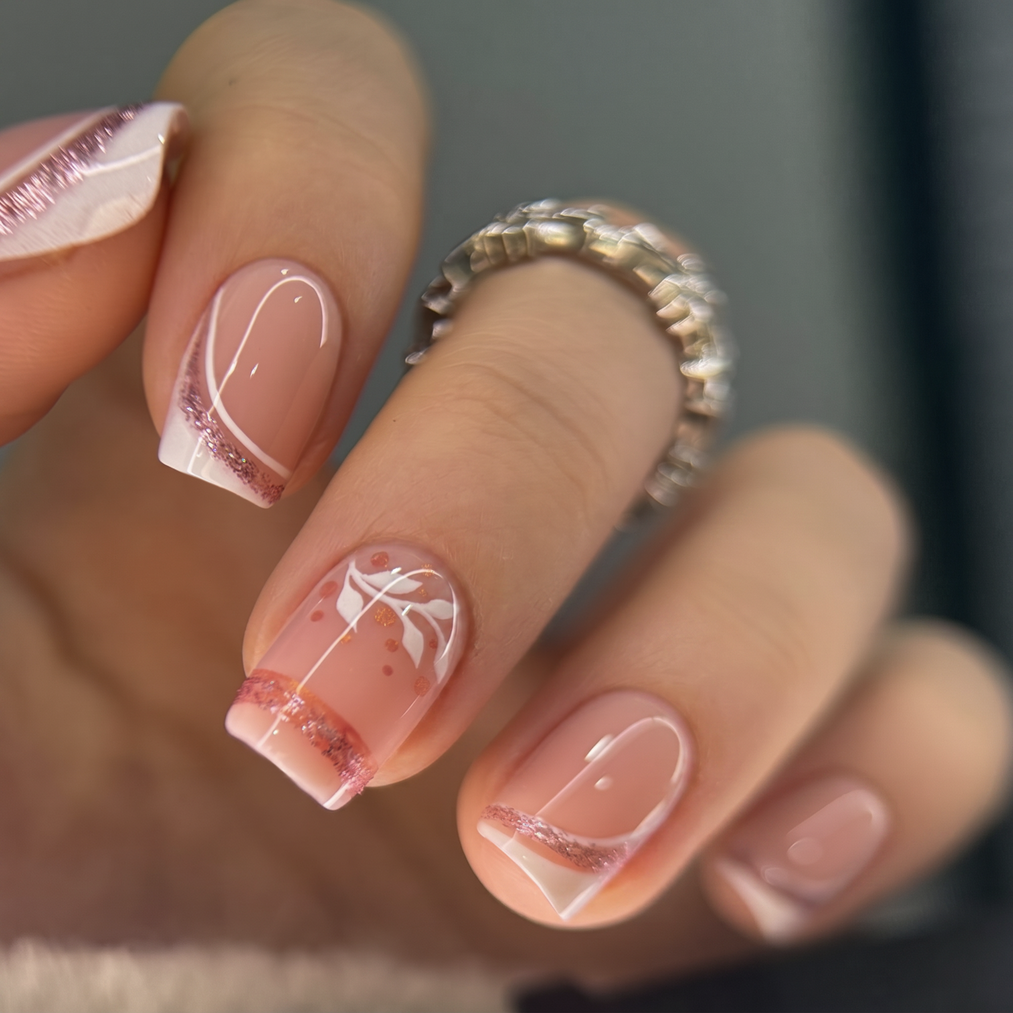 Rose Gold short squoval press-on nails worn on a hand