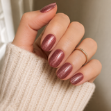 Rose Shimmer Cat Eye short oval press-on nails worn on a hand