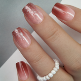 Rosewood Glide short squoval press-on nails worn on a hand