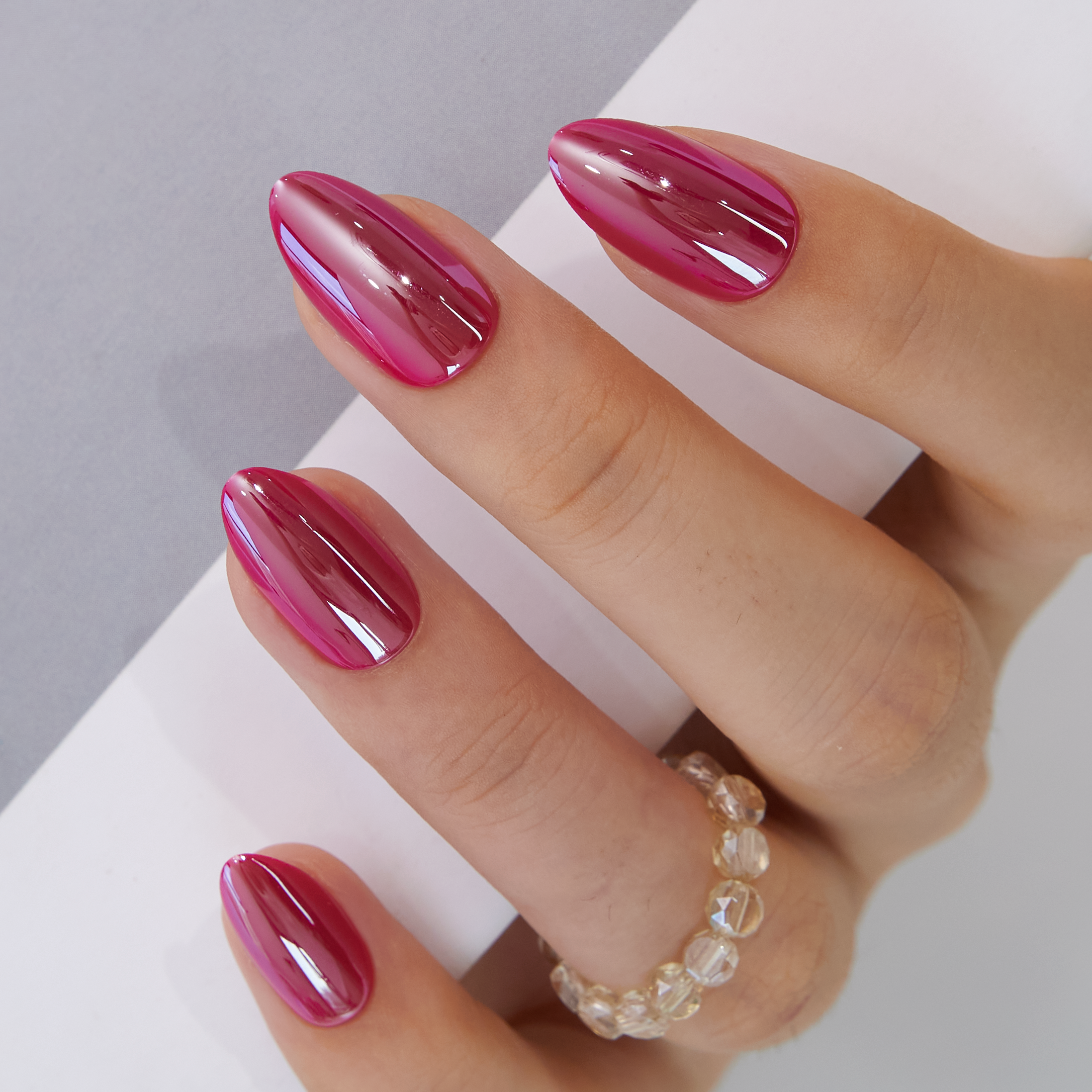 Rosy Glow Shine short almond press-on nails worn on a hand
