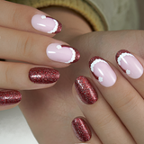 Ruby Charm medium oval press-on nails worn on a hand