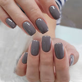 Sleek Slate Gray medium squoval press-on nails worn on a hand