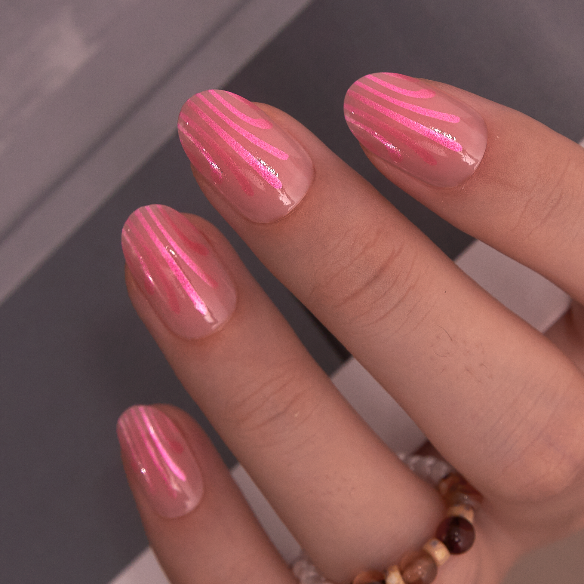 Soft Pink Pearl short oval press-on nails worn on a hand