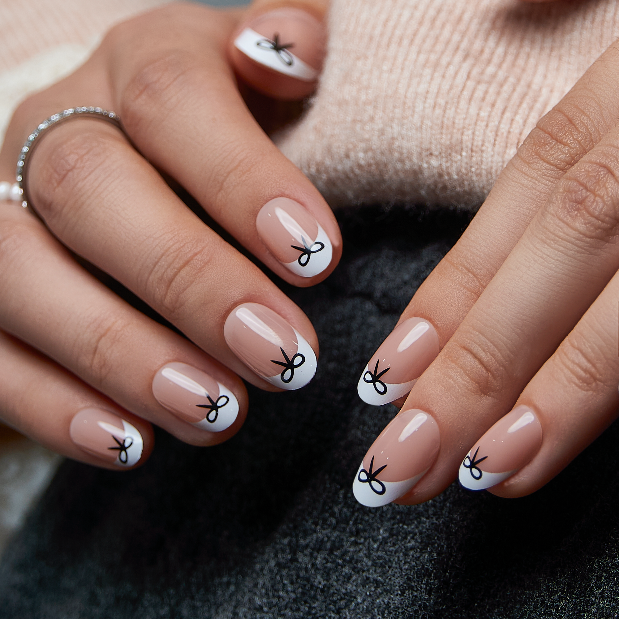 Sweet Knot short oval press-on nails worn on a hand