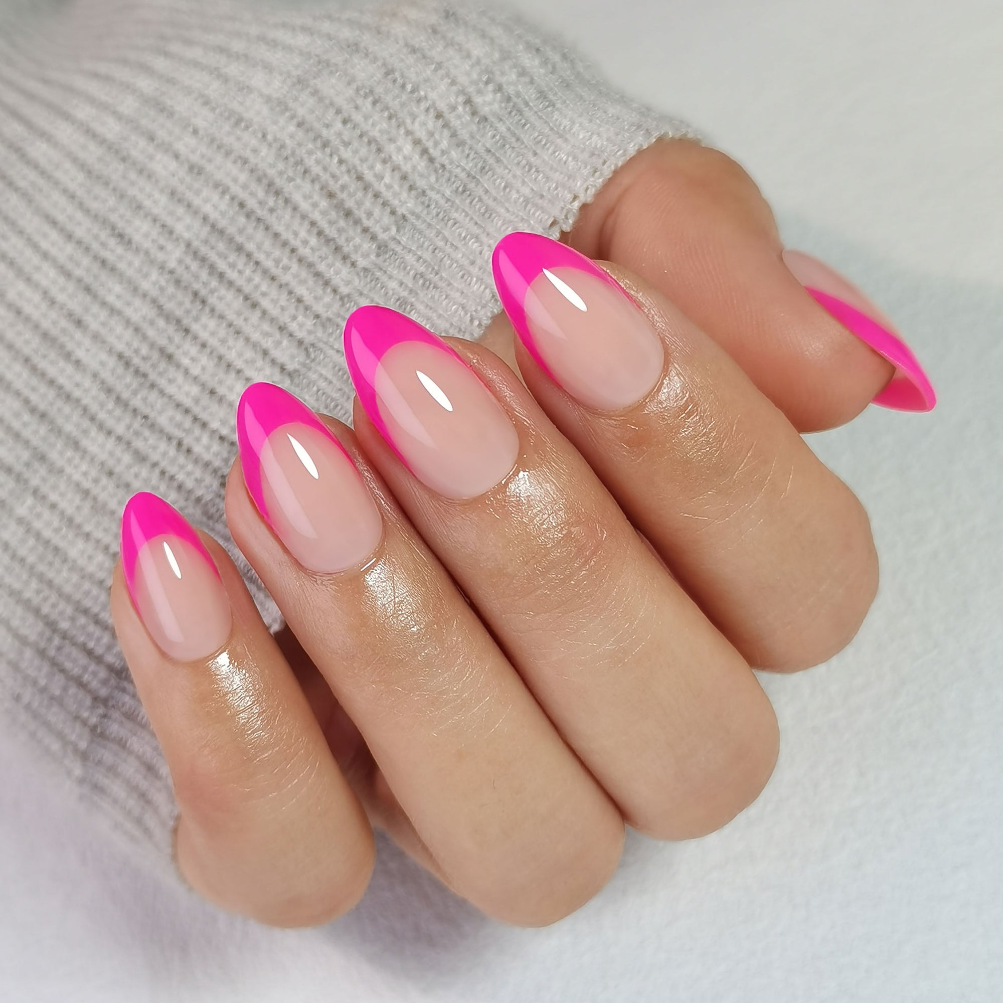 Vibrant Pink short almond press-on nails worn on a hand