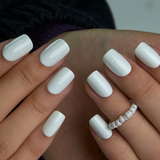White Pearl medium squoval press-on nails worn on a hand