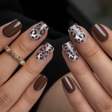 Wild Chic Spots short squoval press-on nails worn on a hand