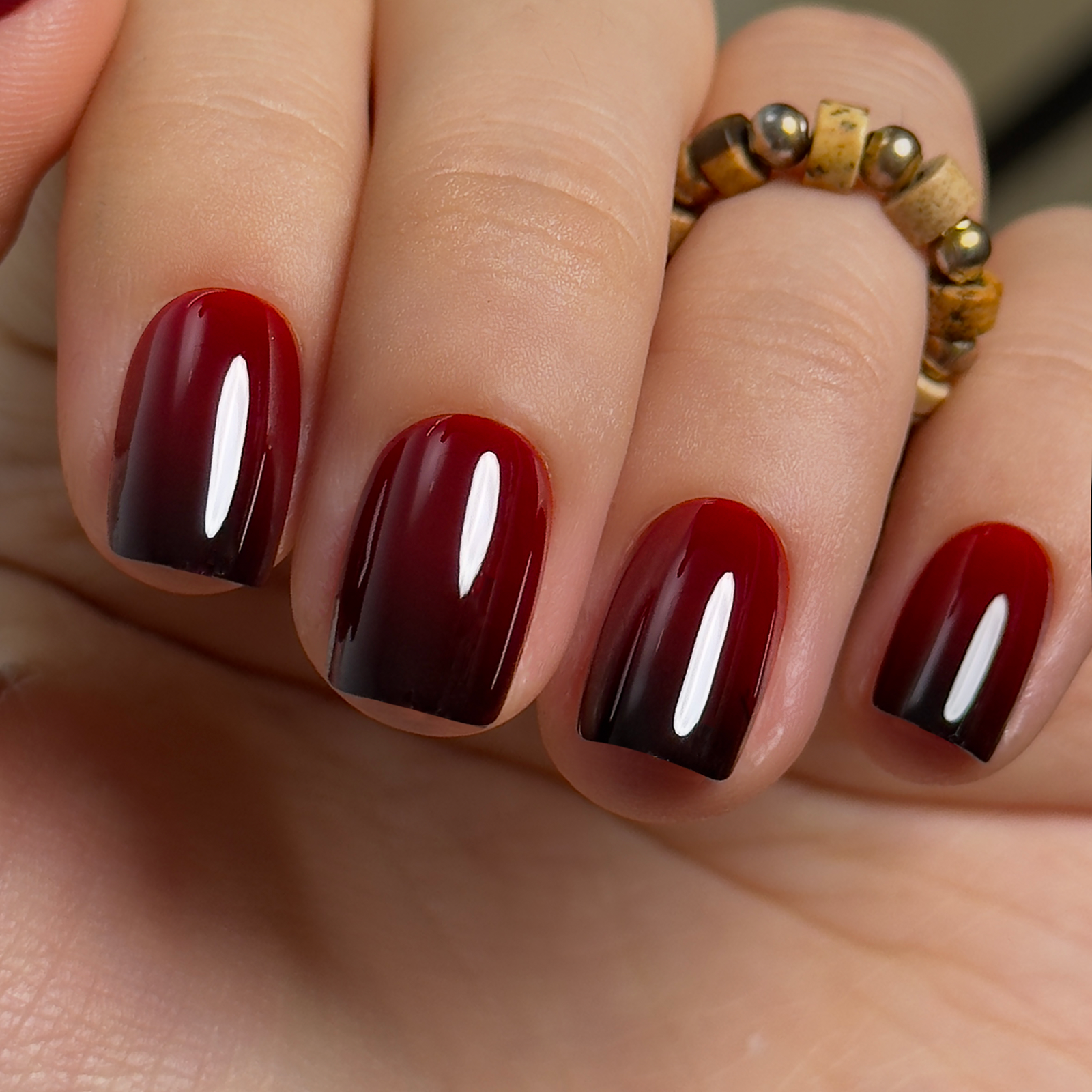 Wine Ombre short squoval press-on nails worn on a hand